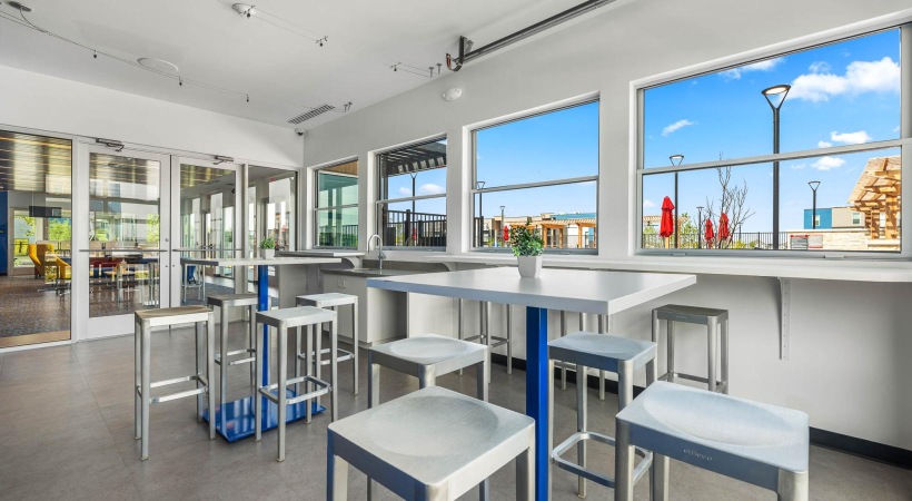 a room with windows tables and chairs