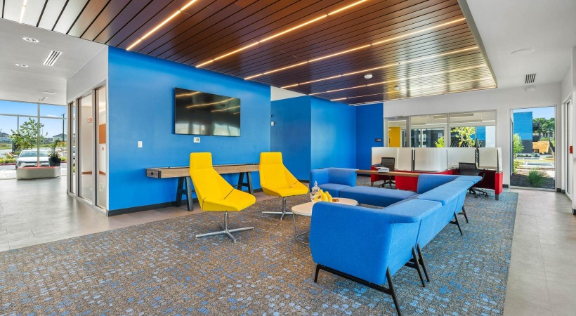 a room with blue and yellow chairs and a tv